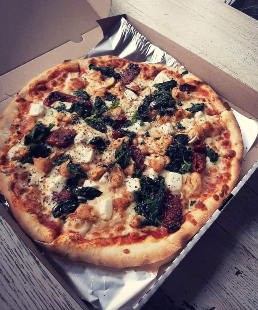 Pizza with spinach, sun-dried tomatoes, and mozzarella