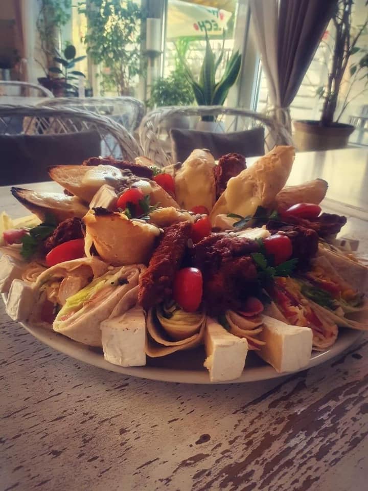 Imponujący talerz z tortillami, fetą, suszonymi pomidorami i pomidorkami cherry