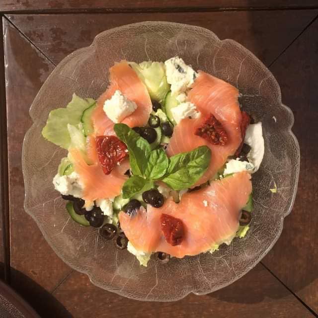 Beautiful salmon salad with cheese, olives, and sun-dried tomatoes